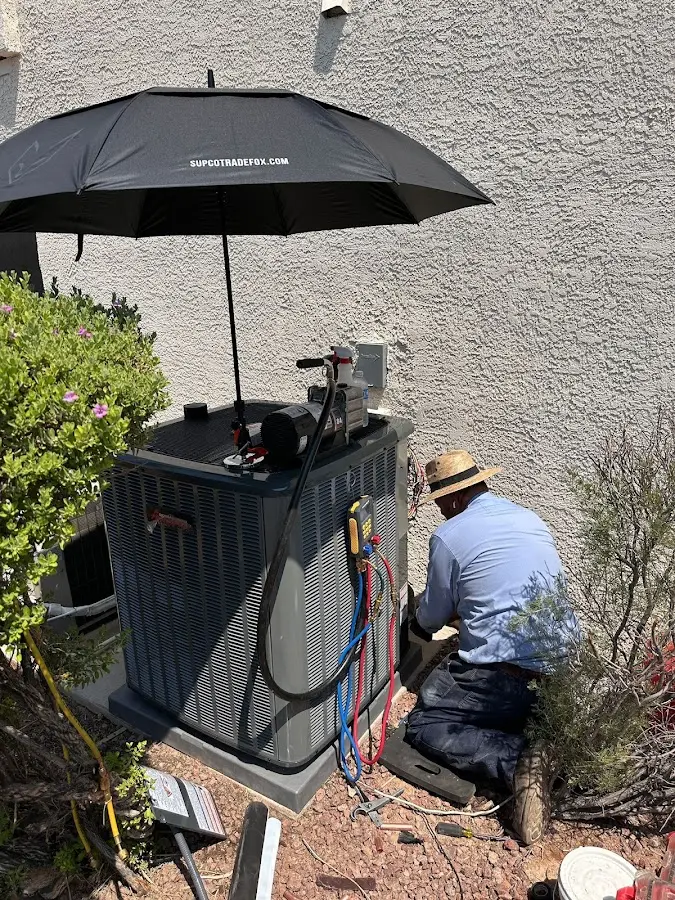 HVAC technician performing outdoor AC maintenance in Bangor